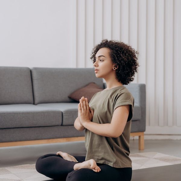 Person meditating peacefully in a comfortable home setting.